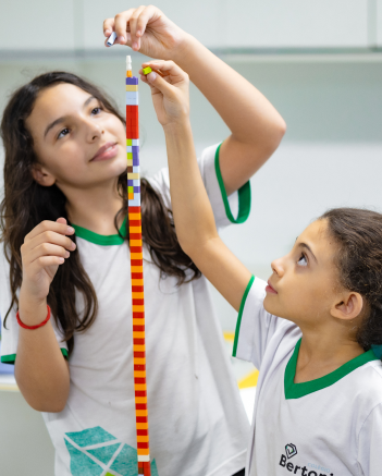 Estudentes construindo uma torre com lego
